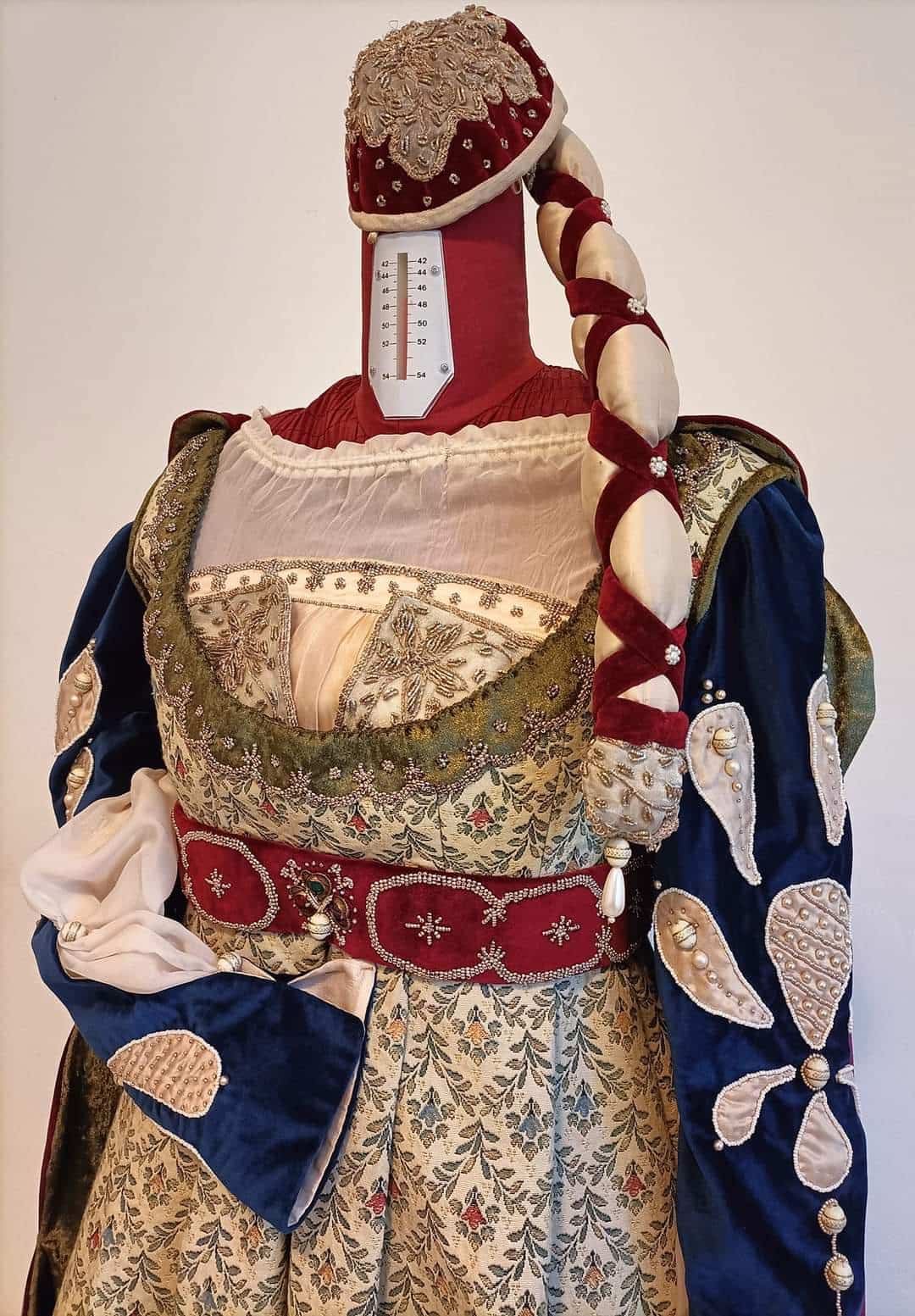 Costume storico rinascimentale realizzato da Olga Generalova Sartachedanza, esposto su manichino con dettagli ricamati, maniche in velluto e acconciatura intrecciata