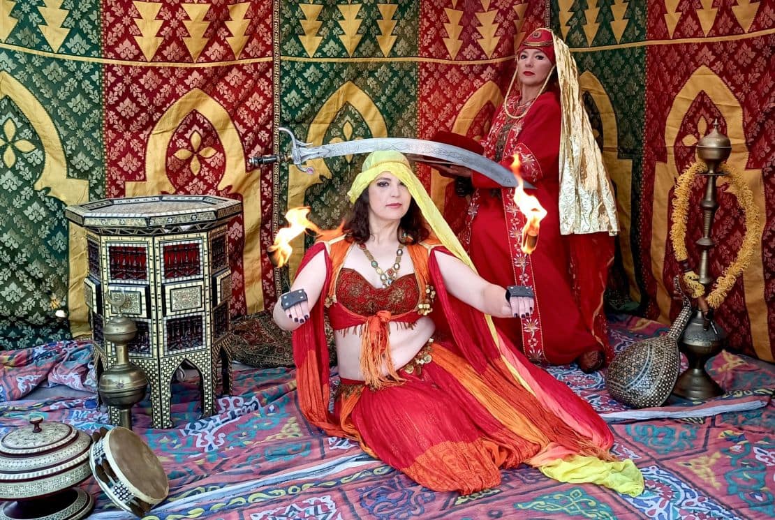 Interpreti del gruppo Venus in personaggi epici con riti antichi, performance con fuoco e allestimento di tenda araba