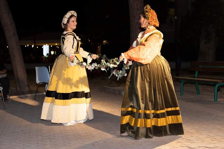 Interpreti del gruppo Venus in danza rinascimentale con abiti storici e ghirlanda floreale in scena notturna