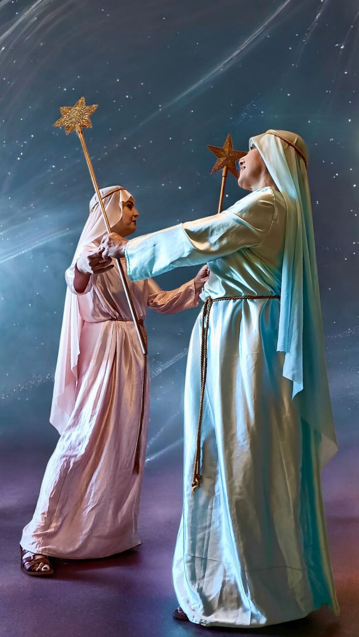 Pastorelle in costumi tradizionali che eseguono balli sacri e popolari della tradizione natalizia con stelle luminose.