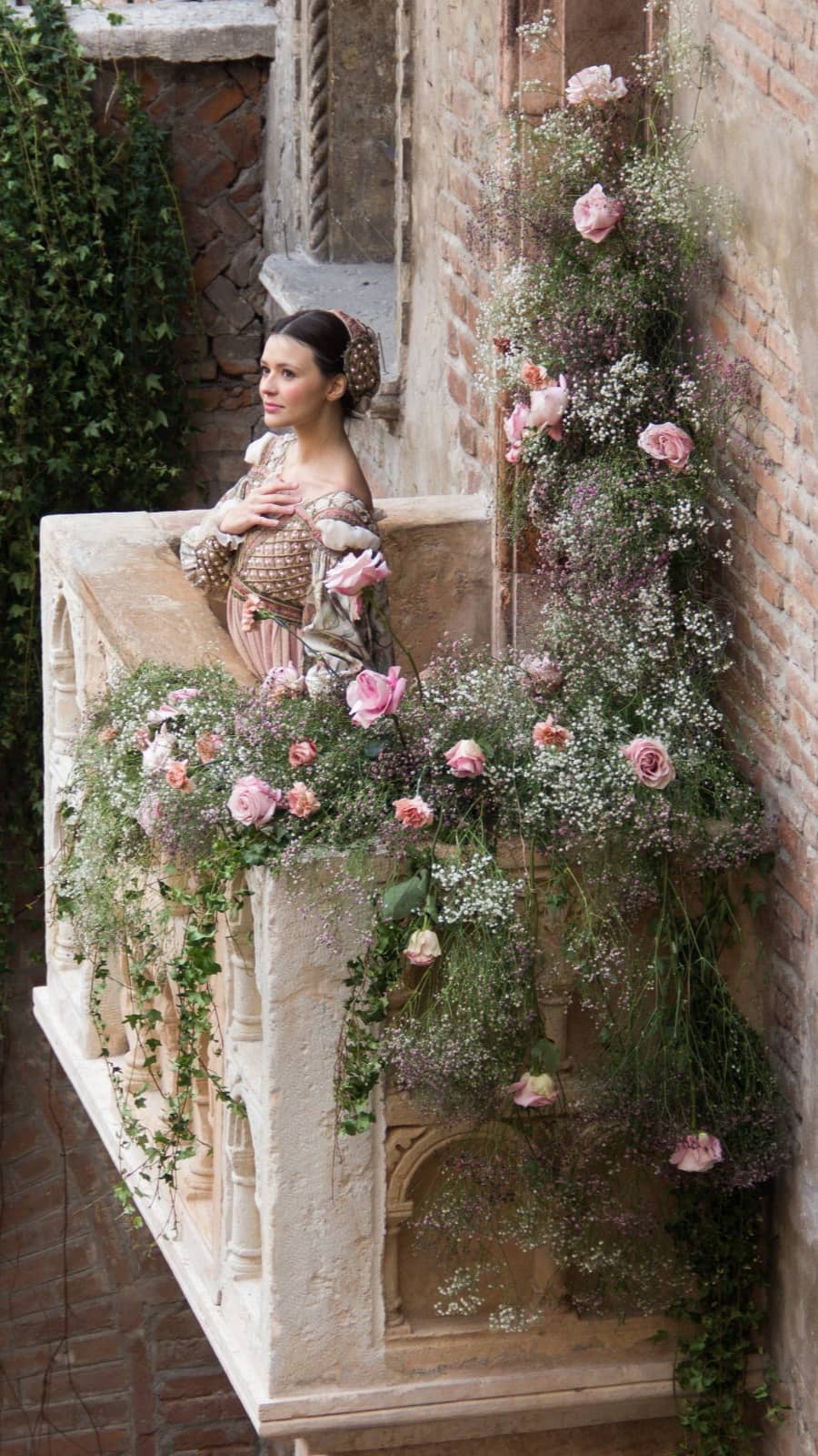 Vestito rinascimentale realizzato da Olga per il Club di Giulietta, indossato da testimonial sul balcone di casa di Giulietta con dettagli sartoriali visibili